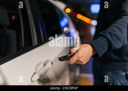 Uomo d'affari che sblocca la porta dell'auto con la chiave Foto Stock