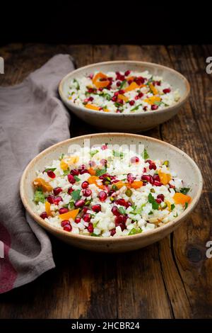 Shot studio di due ciotole di insalata di cavolfiore con semi di melograno, pistacchi, menta, prezzemolo e albicocca Foto Stock