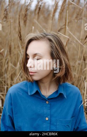 Felice madre che porta la bambina e fiori di camomilla Foto Stock