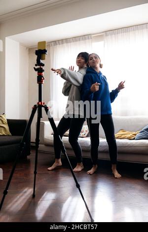 Gli amici che filmano ballare a casa con il telefono cellulare Foto Stock