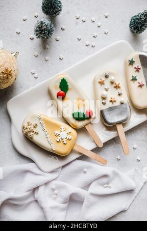 Mano di ragazzo da albero di Natale fatto da accatastare biscotti in piatto sul tavolo Foto Stock