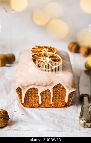Torta di pane all'arancia con luccicante sul tavolo Foto Stock