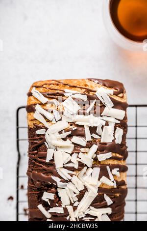 Fette di torta al cioccolato e alla vaniglia con un bicchiere di vino sul tavolo Foto Stock