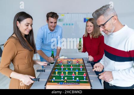 I colleghi a giocare a biliardino in office Foto Stock