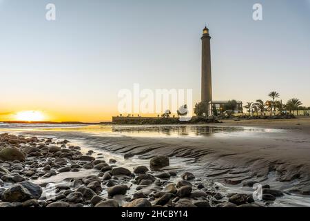 Faro sulla costa rocciosa durante il tramonto a Maspalomas, Gran Canaria, Spagna Foto Stock