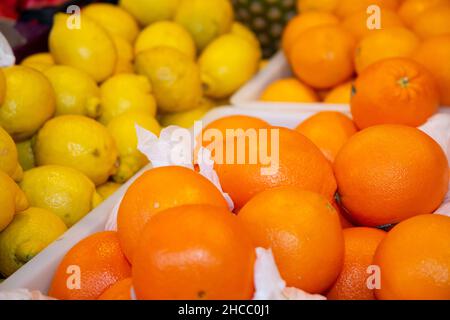 Arance e limoni alla bancarella di frutta e verdura al mercato settimanale Foto Stock