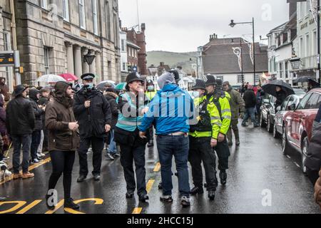 Lewes, Regno Unito. 25th Dic 2021. Centinaia di manifestanti hanno affrontato un gruppo di cacciatori che hanno partecipato a una sfilata annuale. Ogni anno, i cavalieri di Southdown e Eridge Foxhounds sfilano attraverso il centro di Lewes. I piloti affermano che sono solo caccia al trascinamento. Questa mattina, centinaia di manifestanti anti anti-caccia si sono schierati lungo la strada principale della città per dimostrare contro la brigata che si è fatta strada a cavallo. Credit: @Dmoonuk/Alamy Live News Foto Stock