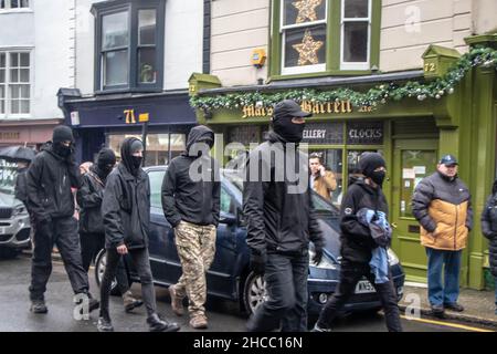 Lewes, Regno Unito. 25th Dic 2021. Centinaia di manifestanti hanno affrontato un gruppo di cacciatori che hanno partecipato a una sfilata annuale. Ogni anno, i cavalieri di Southdown e Eridge Foxhounds sfilano attraverso il centro di Lewes. I piloti affermano che sono solo caccia al trascinamento. Questa mattina, centinaia di manifestanti anti anti-caccia si sono schierati lungo la strada principale della città per dimostrare contro la brigata che si è fatta strada a cavallo. Credit: @Dmoonuk/Alamy Live News Foto Stock