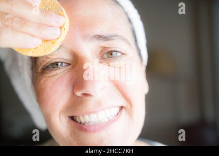 Cura del viso e del corpo con creme. Felice donna di mezza età Foto Stock