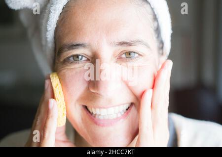 Cura del viso e del corpo con creme. Felice donna di mezza età Foto Stock