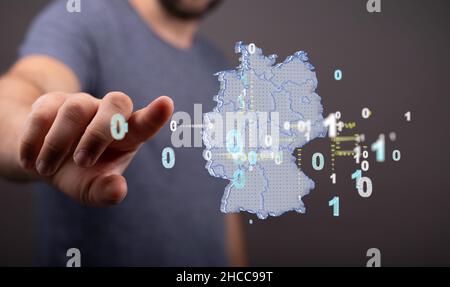 Primo piano della mano che punta al modello virtuale della mappa tedesca con numeri binari. Foto Stock