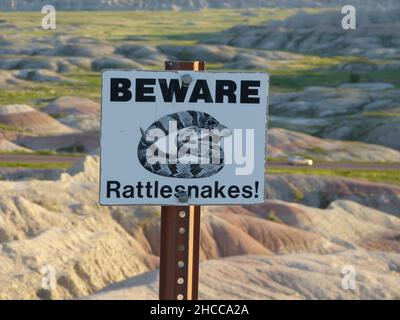 Cartello con un messaggio di avvertimento: "Attenzione ai rattlesnakes nel Badlands National Park Interior, USA Foto Stock