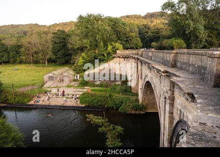 La gente si raduna per nuotare selvaggio e canottaggio nel fiume Avon sotto Dundas Aquaduct vicino Bath. Foto Stock