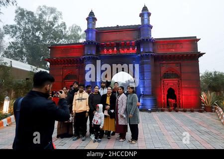 New Delhi, India. 26th Dic 2021. I visitatori posano per una foto di fronte a una replica di Gateway of India al Bharat Darshan Park a New Delhi. Il parco ha riproduzioni di diversi monumenti iconici dell'India costruiti con rottami e rifiuti. Credit: SOPA Images Limited/Alamy Live News Foto Stock