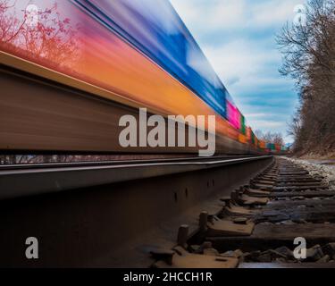 Primo piano del treno in movimento sulla ferrovia contro un cielo nuvoloso in inverno Foto Stock