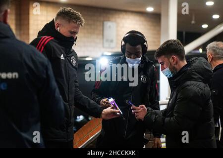*NOTA EDITORIALI: Questa immagine è stata pixelata per garantire che il codice QR non sia visibile*. Dean Henderson del Manchester United (a sinistra) e Anthony Elanga del Manchester United (a destra) hanno i loro passi scansionati all'arrivo prima della partita della Premier League al St. James' Park, Newcastle. Data foto: Lunedì 27 dicembre 2021. Foto Stock