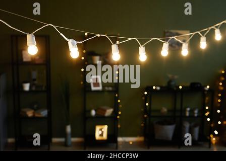 Camera accogliente con pareti color verde pastello, luci luminose in primo piano e scaffali su sfondo Foto Stock