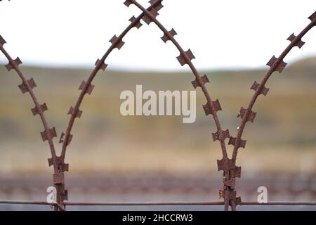 Barriera filo per rasoio arrugginito all'aperto Foto Stock
