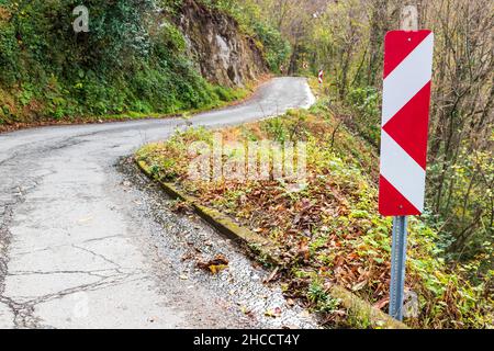 Direzione di svolta, cartello stradale protettivo su strada di montagna in svolta Foto Stock