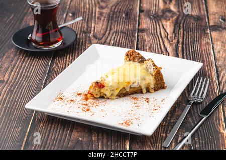 Torta quiche di funghi con tè su piatto bianco su tavola di legno Foto Stock