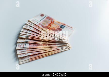 Banconote di cinquemila rubli russi giacenti su tavola bianca. Vista dall'alto Foto Stock