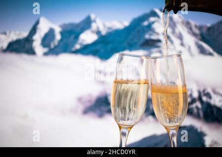 Bicchieri di champagne e picchi innevati in background Capodanno Foto Stock