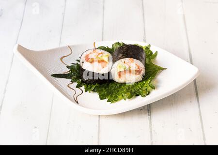 Il rotolo di salmone futomaki è una delle varietà del grande ambasciatore della gastronomia giapponese, il sushi. Quando si pensa al cibo giapponese, immediatamente Foto Stock