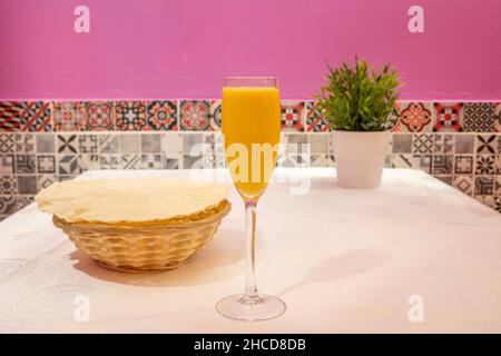 Per preparare il mango lassi, mettere il kefir (o yogurt) in un bicchiere americano e aggiungere un seme di cardamomo, la curcuma e il mango tritato. Cospargere con Foto Stock