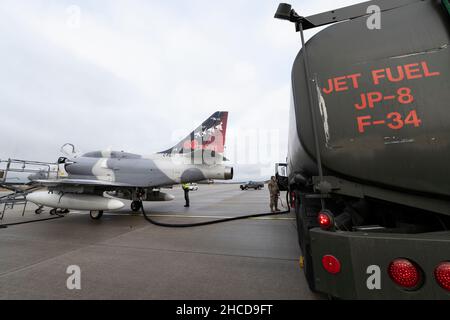 US Air Force Airman 1st Classe Joshua Skroch, 52nd Logistics Readiness Squadron Fuels Management Flight Fuels distribution operator, Refuels a Top Aces A-4 Skyhawk from a U.S. Air Force R-11 FUEL Truck durante una valutazione di utilità di ADAIR (ADAIR) su Spangdahlem Air base, Germania, 15 dicembre 2021. Il Douglas A-4 Skyhawk fu progettato per la prima volta come un aereo da attacco a reazione per la Marina degli Stati Uniti e il corpo Marino nel 1950s. (STATI UNITI Air Force foto di Tech. SGT. Maeson L. Elleman) Foto Stock