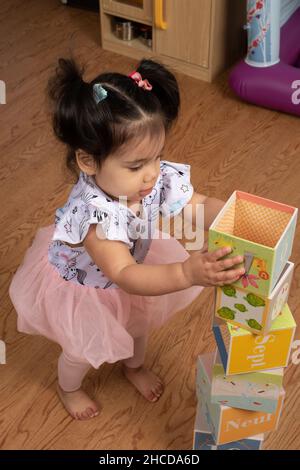 toddler girl 17 mesi accatastando i blocchi di cartone Foto Stock