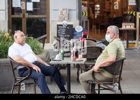 Foto di bianchi anziani caucasici a belgrado, serbia, seduti sulla terrazza di un caffè per le strade di Belgrado, capitale della Serbia, mentre Foto Stock