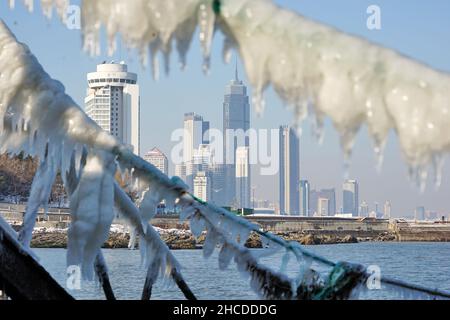 YANTAI, CINA - 27 DICEMBRE 2021 - il ghiaccio marino si forma sulla catena di una recinzione marittima a Yantai, provincia di Shandong, Cina, 27 dicembre 2021. Foto Stock