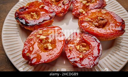 Vista panoramica cotogna cotta fatta in casa con miele, noce e cannella su piastra luminosa, fuoco selettivo Foto Stock