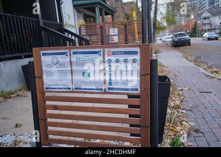 Ottawa, Ontario, Canada - 14 novembre 2021: Le indicazioni da Ottawa Public Health al di fuori di un ristorante nel centro città descrivono le regole COVID-19. Foto Stock