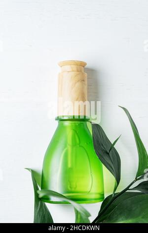 flacone per la cura della pelle cosmetica naturale con pipetta e foglia verde organica su sfondo bianco. Rimedio fatto in casa e concetto di prodotto di bellezza Foto Stock