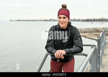 Lindau am Bodenseee, Germania. 16th Dic 2021. L'atleta Valeria Kleiner corre lungo la riva del lago di Costanza. Kleiner ha giocato nelle selezioni DFB, ha vinto i titoli, ha giocato nella Bundesliga di calcio femminile. Le lesioni hanno causato un cambiamento. Ora inizia come triatleta professionista. Credit: Felix Kästle/dpa/Alamy Live News Foto Stock