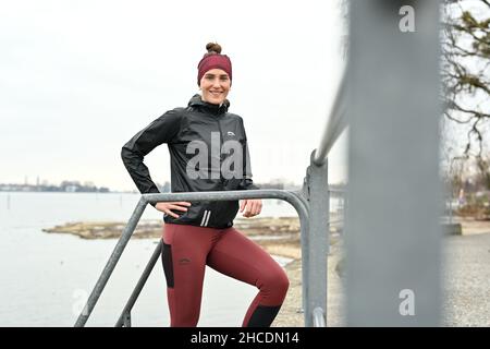 Lindau am Bodenseee, Germania. 16th Dic 2021. L'atleta Valeria Kleiner corre lungo la riva del lago di Costanza. Kleiner ha giocato nelle selezioni DFB, ha vinto i titoli, ha giocato nella Bundesliga di calcio femminile. Le lesioni hanno causato un cambiamento. Ora inizia come triatleta professionista. Credit: Felix Kästle/dpa/Alamy Live News Foto Stock