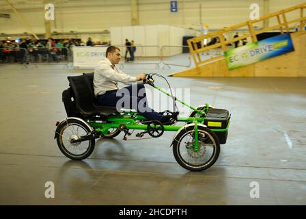 Il giovane cavalcando su una bicicletta elettrica fatta in casa su una pista ciclabile. Bike Expo-2019. Marzo 8, 2019. Kiev, Ucraina Foto Stock