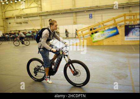 Il giovane cavalcando su una bicicletta elettrica fatta in casa su una pista ciclabile. Bike Expo-2019. Marzo 8, 2019. Kiev, Ucraina Foto Stock