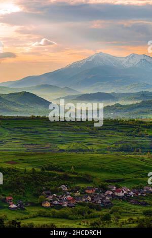 Maramures contea con case dalla città di Ieud e le possenti Carpazi montagne dietro, durante un nebbiosa alba. Foto scattata il 16th maggio 2021 vicino a i Foto Stock
