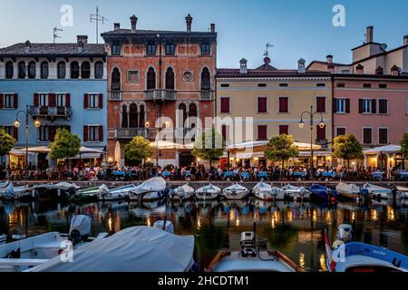 Vista blu ora del porto turistico di Desenzano del Garda con ristoranti all'aperto. Photo taken on 20th of August 2021 a Desenzano del Garda, provincia di Brescia, Lomba Foto Stock