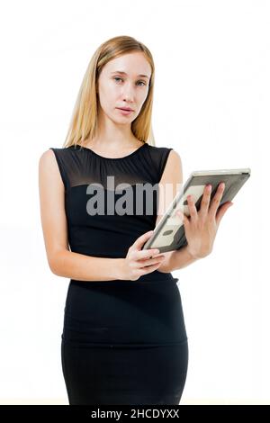 Giovane donna in abito nero usa un tablet Foto Stock