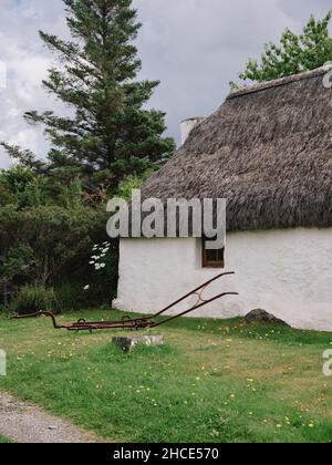 Un tradizionale cottage croft con tetto in paglia nel villaggio di Plockton sulle rive di Loch Carron a Lochalsh, Wester Ross, West Highlands Scozia UK Foto Stock