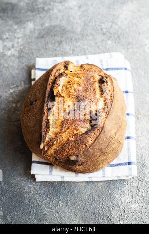 Pane fresco di pasta madre con albicocche secche e prugne secche su sfondo grigio. Primo piano. Foto Stock