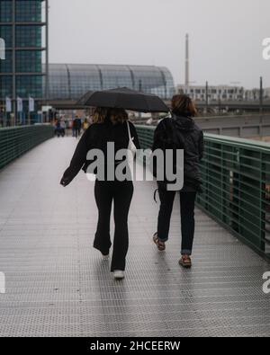 Colpo verticale di due donne che camminano lungo la strada. Foto Stock