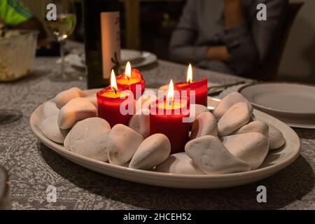 La corona dell'Avvento con quattro candele rosse segnano la celebrazione del Natale. Foto Stock