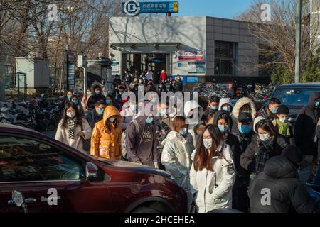 I pendolari del mattino escono dall'uscita della metropolitana a Zhongguancun, centro tecnologico di Pechino, Cina. 27-dic-2021 Foto Stock