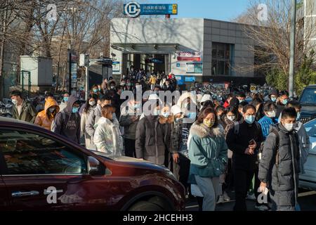 I pendolari del mattino escono dall'uscita della metropolitana a Zhongguancun, centro tecnologico di Pechino, Cina. 27-dic-2021 Foto Stock