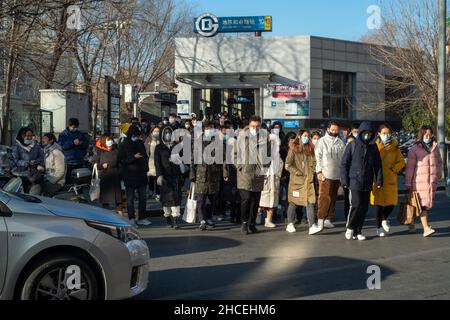 I pendolari del mattino escono dall'uscita della metropolitana a Zhongguancun, centro tecnologico di Pechino, Cina. 27-dic-2021 Foto Stock