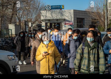 I pendolari del mattino escono dall'uscita della metropolitana a Zhongguancun, centro tecnologico di Pechino, Cina. 27-dic-2021 Foto Stock